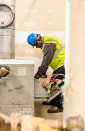 Man bending over wearing a hard hat.